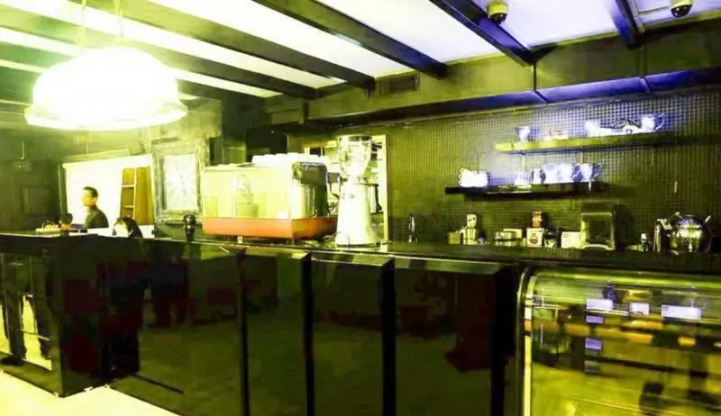 دکوراسیون داخلی شیک و مدرن رستوران ایتالیایی جنارو، فضایی دلنشین و دنج با پیشخوان کافه، دستگاه‌های قهوه و نورپردازی خاص.