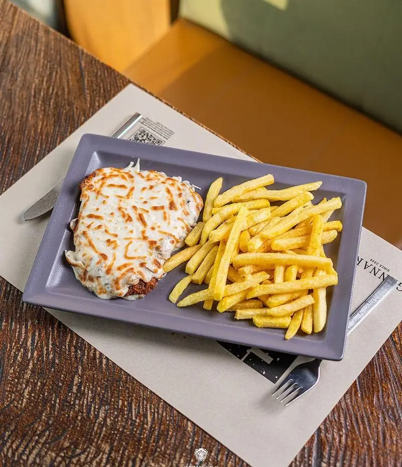 غذای لذیذ و پرطرفدار رستوران ایتالیایی جنارو: یک پرس بزرگ غذای پنیری با سیب‌زمینی سرخ کرده، ایده‌آل برای ناهار یا شام.