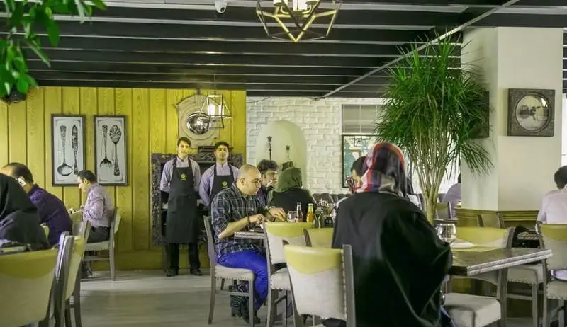 فضای داخلی شیک و مدرن رستوران ایتالیایی جنارو با مشتریان در حال غذا خوردن، دکوراسیون چشم‌نواز و محیطی دلنشین برای صرف غذا.