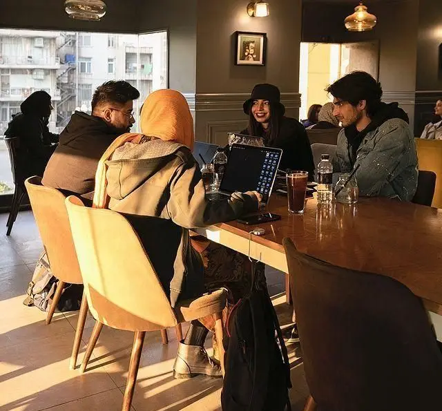 مشتریان در کافه قنادی بیترسوییت مشغول کار با لپ‌تاپ و نوشیدن قهوه در فضای دنج و آفتابی. محیطی دلنشین برای دورهمی.