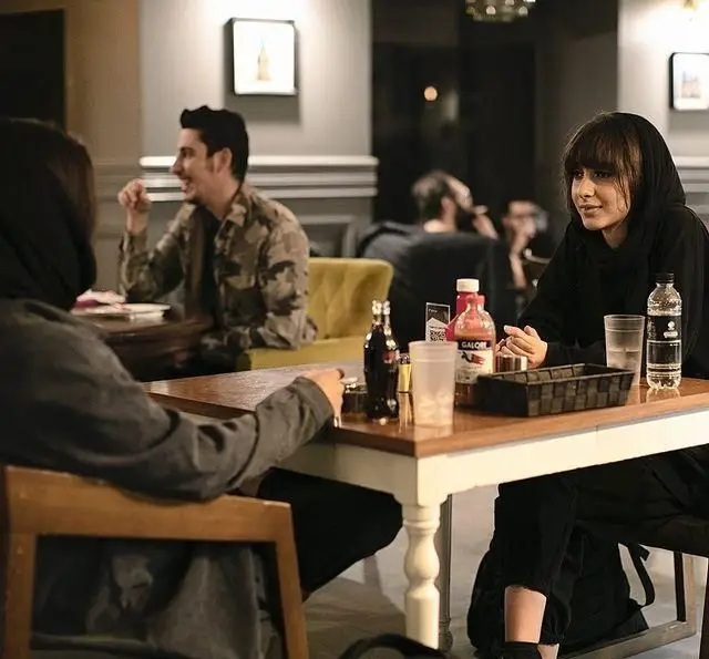 مشتریان شاد در کافه قنادی بیترسوییت، دو زن و یک مرد در حال گپ و گفت و نوشیدن در فضایی دوستانه و دلنشین، تجربه شیرین در کافه.