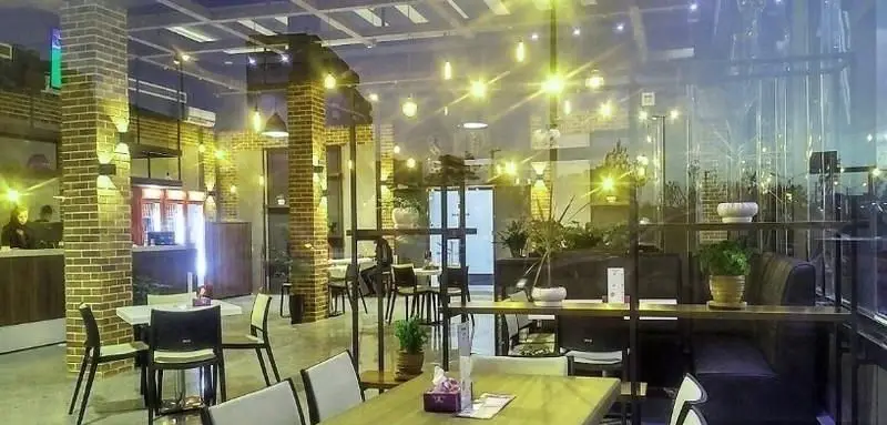 فضای داخلی مدرن و دلنشین فست فود سیب360 با دکوراسیون آجری، نورپردازی گرم و مبلمان راحت برای تجربه غذایی لذت‌بخش.