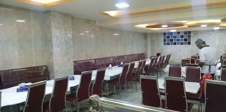 محیط داخلی بزرگ و دلنشین رستوران اغذیه نشاط با چیدمان مرتب میز و صندلی‌ها، آماده پذیرایی از مشتریان توسط پرسنل.