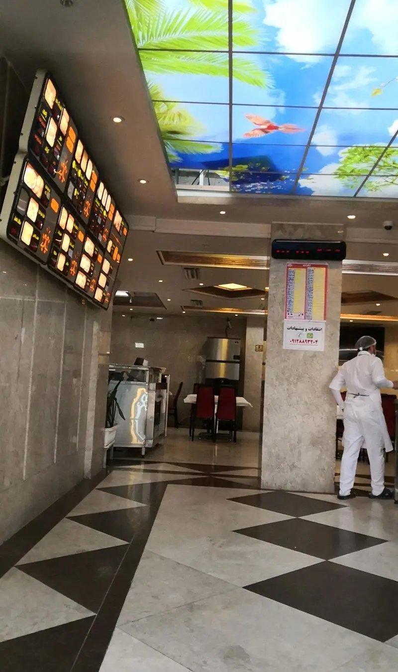 دکوراسیون داخلی رستوران اغذیه نشاط: سقف تصویری خلاقانه، منوی غذاهای متنوع، کفپوش طرح‌دار و فضایی دلنشین برای مشتریان.