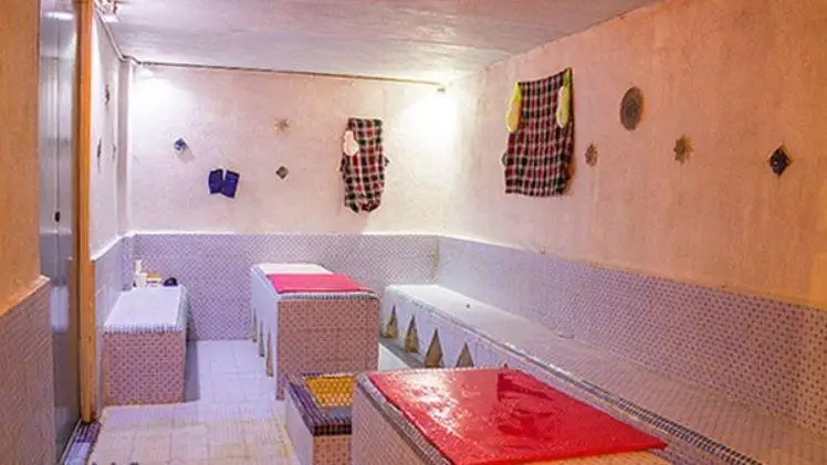 فضای داخلی تمیز و مرتب استخر روباز آفتاب، شامل رختکن، نیمکت‌ها و سکوهای آماده‌سازی با دیوارهای کاشی‌کاری شده.