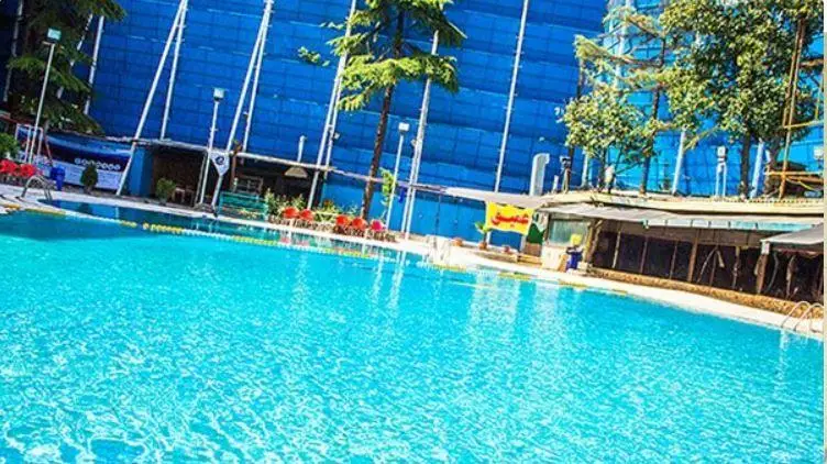 استخر روباز آفتاب با آب فیروزه‌ای و خطوط شنا مشخص، محیطی دنج و دلنشین برای علاقه‌مندان به شنا و آرامش در طبیعت.