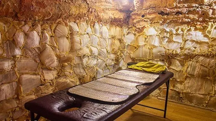 اتاق نمک درمانی لوکس استخر روباز آفتاب با تخت ماساژ و محیطی آرامش‌بخش برای سلامت و ریلکسیشن مشتریان.