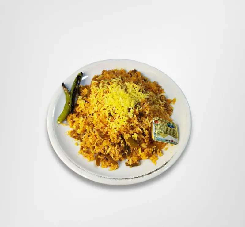 پلو زعفرانی و سبزیجات تازه در بشقاب، مزین به فلفل سبز تند و کره، غذایی پرطرفدار و با کیفیت از رستوران امینی.