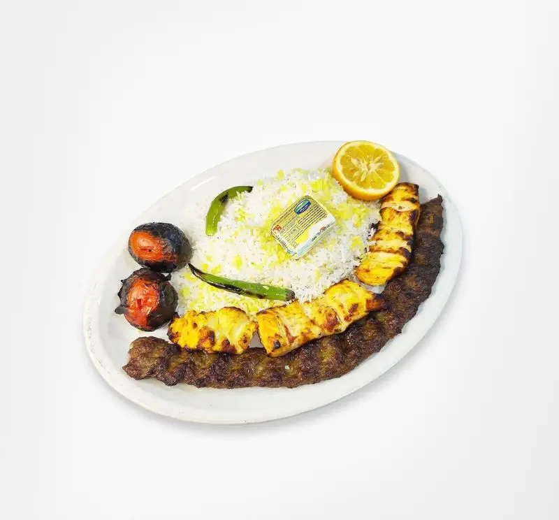 چلو کباب کوبیده و جوجه رستوران امینی با برنج زعفرانی، گوجه کبابی، کره و لیمو. طعم اصیل غذای ایرانی.