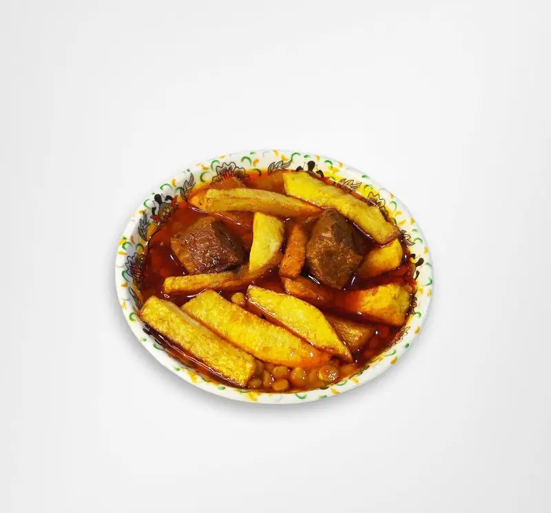 خورش قیمه سیب‌زمینی خوشمزه و اصیل رستوران امینی، غذای سنتی ایرانی با گوشت و سیب‌زمینی سرخ کرده تازه در یک کاسه طرح‌دار زیبا.