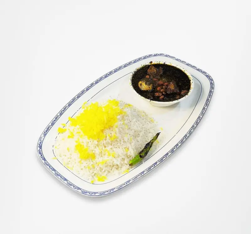 غذای اصیل ایرانی: خورشت قورمه سبزی و پلو با تزئین زعفرانی در رستوران امینی، تجربه‌ای لذیذ و به یادماندنی از طعم‌های سنتی.