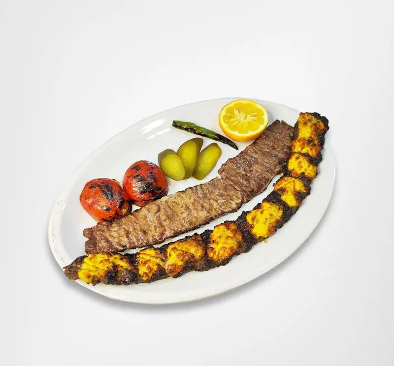 غذای اصیل ایرانی: کباب کوبیده و جوجه کباب لذیذ رستوران امینی با گوجه کبابی، خیارشور و لیمو. تجربه طعم بی نظیر!