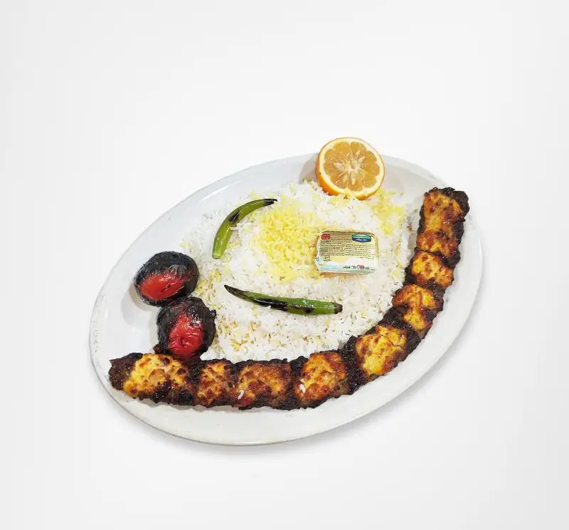 چلو جوجه کباب لاری رستوران امینی، یک غذای خوشمزه و کامل شامل مرغ کبابی، برنج زعفرانی، گوجه و فلفل کبابی.