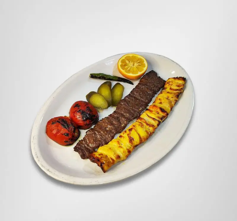 کباب لذیذ رستوران امینی: یک سیخ کباب کوبیده و یک سیخ جوجه کباب به همراه گوجه کبابی، خیارشور و لیمو تازه، غذای اصیل ایرانی