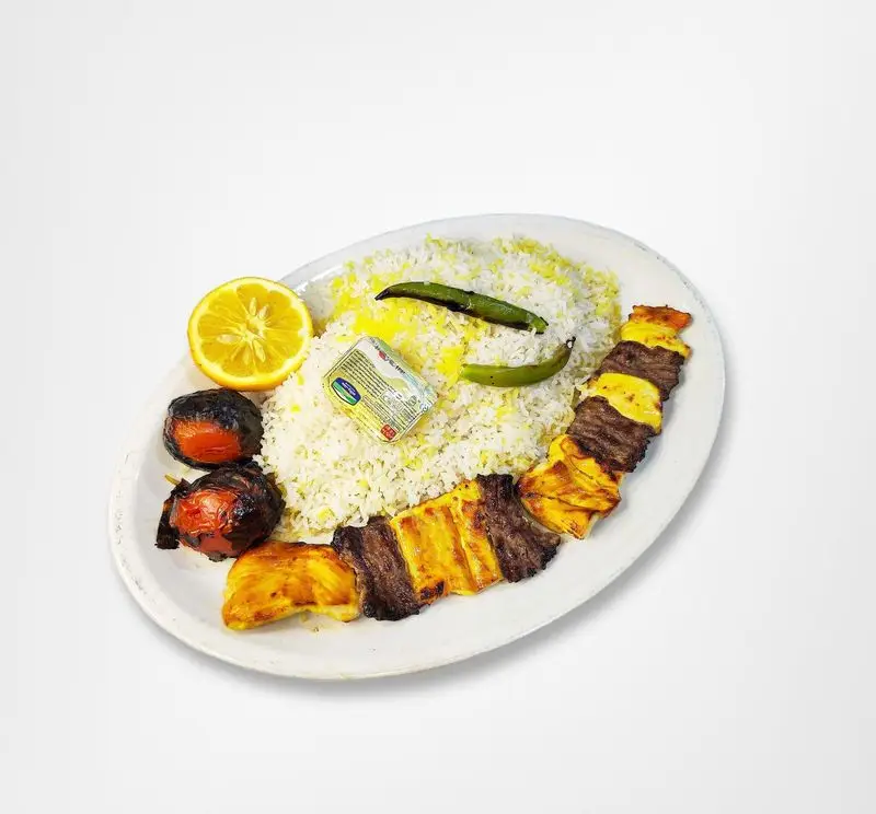 چلوکباب کوبیده خوشمزه با برنج زعفرانی، گوجه کبابی و لیمو تازه از رستوران امینی، بهترین انتخاب برای غذای ایرانی.