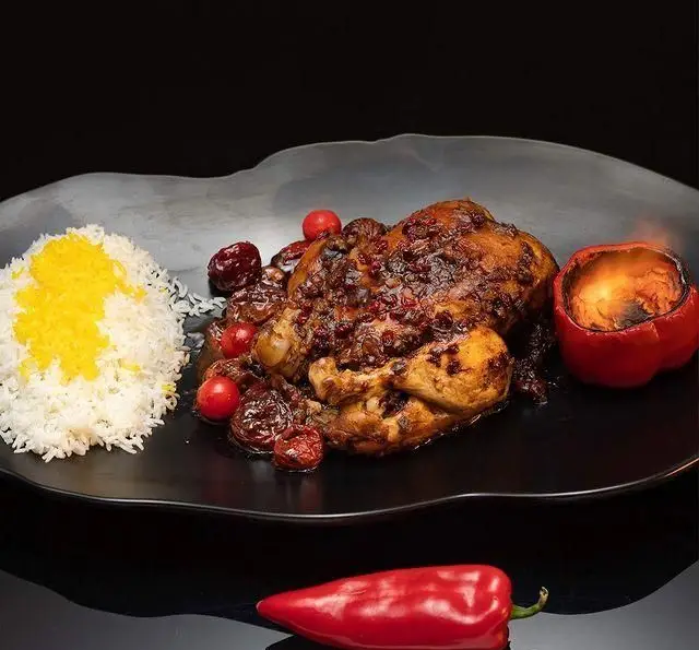 غذای سنتی و خوشمزه کافه رستوران گرپ: خورشت مرغ مجلسی با زرشک و آلبالو، سرو شده با پلو زعفرانی و فلفل کبابی. مناسب ناهار و شام.