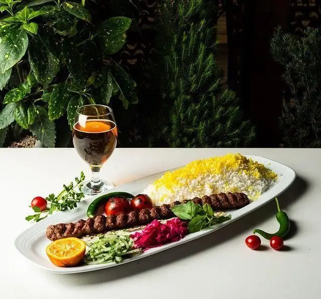 کباب لذیذ ایرانی در کافه رستوران گرپ: کوبیده با برنج زعفرانی و مخلفات تازه، سرو شده با نوشیدنی در محیطی دلپذیر.