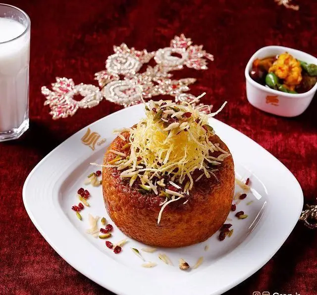 غذای محبوب ته چین مرغ زعفرانی در کافه رستوران گرپ، با تزئینات زیبا و رنگارنگ، آماده سرو به همراه نوشیدنی و ترشی.