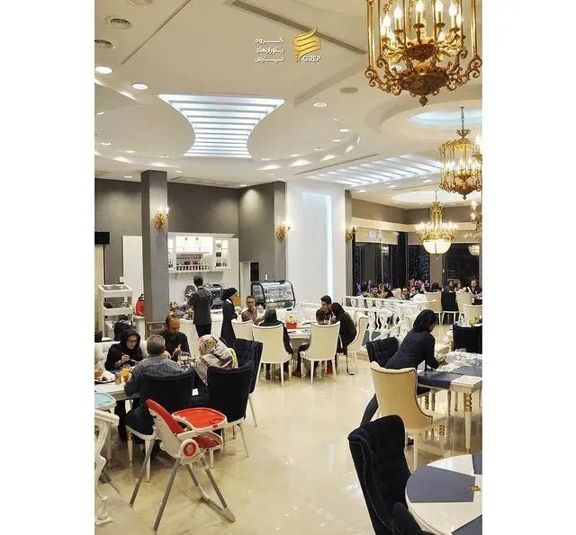 تصویری از فضای داخلی شیک و مدرن کافه رستوران گرپ، با لوسترهای مجلل، مهمانان در حال لذت بردن از غذا و نوشیدنی در محیطی دلنشین و آرام.