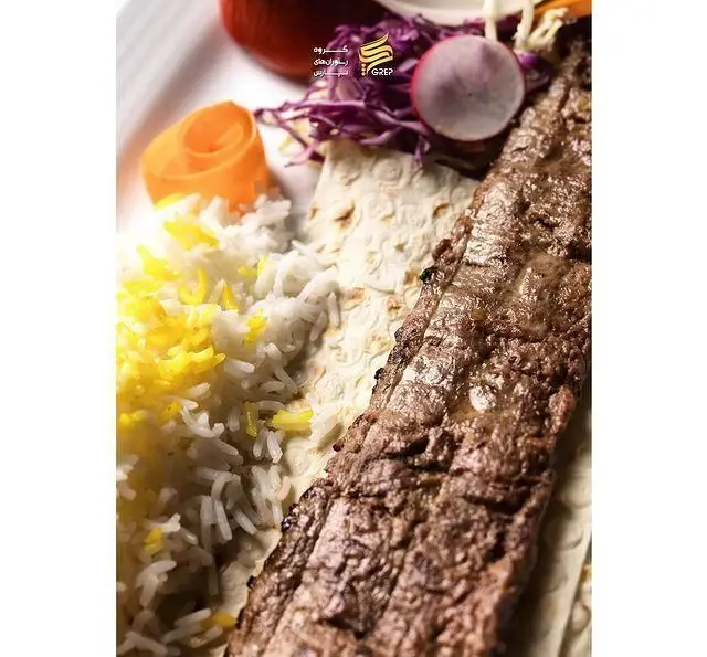 تصویری نزدیک از کباب کوبیده رستوران گرپ با برنج، نان و مخلفات تازه، تجربه‌ای دلپذیر از غذای ایرانی.