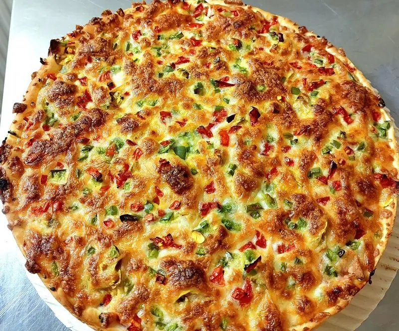 پیتزای داغ با پنیر طلایی برشته، فلفل دلمه‌ای قرمز و سبز تازه از پیتزا علامت سؤال. بهترین طعم فست فود برای سفارش آنلاین.