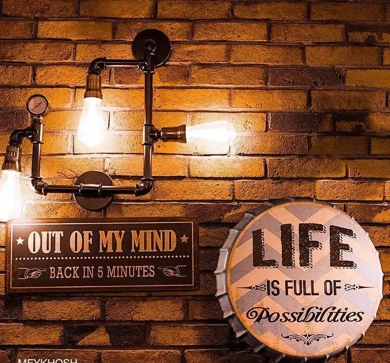 دکوراسیون داخلی رستوران میخوش با دیوار آجری، چراغ‌های لوله‌ای صنعتی و تابلوهای دکوراتیو خاص برای فضایی گرم و جذاب.