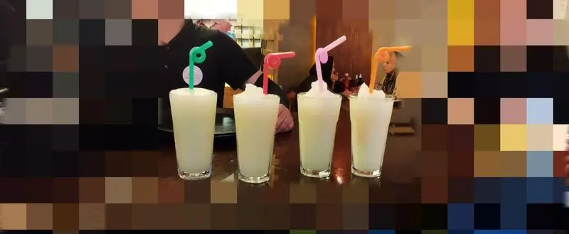 نوشیدنی‌های خنک و دلچسب رستوران میخوش: چهار لیوان پر از اسموتی یخی با نی‌های رنگارنگ، ایده‌آل برای گرما و طراوت.