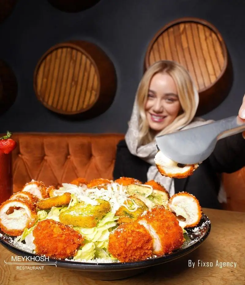 رستوران میخوش: سالاد مرغ سوخاری مجلل با تکه‌های ترد، پنیر و مخلفات تازه در فضایی گرم و دلنشین. تجربه طعمی بی‌نظیر.