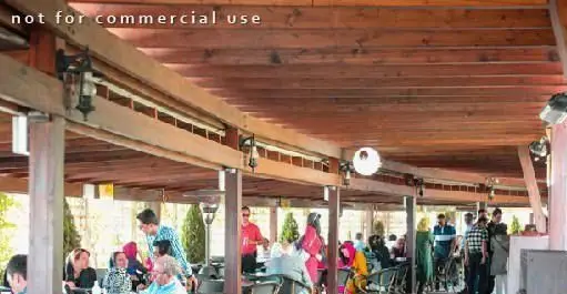 مشتریان در فضای دلنشین و سرپوشیده سالادبار پامولا در حال لذت بردن از غذا و محیط باز رستوران. مکانی عالی برای دورهمی.