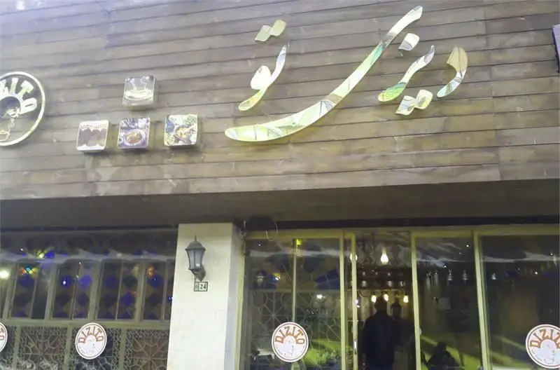 نمای بیرونی کافی شاپ و رستوران دیزی تو با تابلوی بزرگ و جذاب، ورودی دنج با پنجره‌های طرح‌دار و تصاویر غذاهای لذیذ.