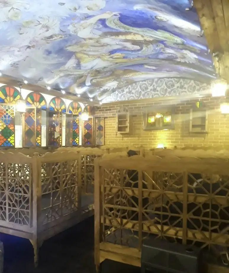 نمایی از فضای داخلی کافی شاپ دیزی تو: سقف نقاشی هنری، ارسی‌های رنگارنگ، تخت‌های سنتی چوبی و آجرکاری سنتی دنج