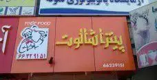 تابلوی روشن نارنجی رنگ فست فود پیتزا شالوت با متن زرد رنگ و لوگوی سرآشپز در حال سرو پیتزا به همراه شماره تلفن جهت سفارش.