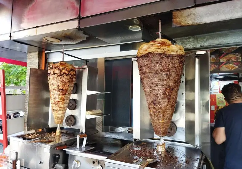 دو سیخ کباب ترکی (دونر) عظیم گوشت و مرغ در اغذیه جوادین، آماده برای ساندویچ‌ها و پرسی‌های تازه و لذیذ.