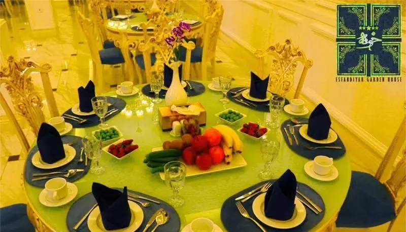 فضای داخلی لوکس رستوران بین المللی خوارزمی با میزهای چیده شده، صندلی‌های طلایی و تزیینات میوه و گل. مناسب شام و مهمانی.