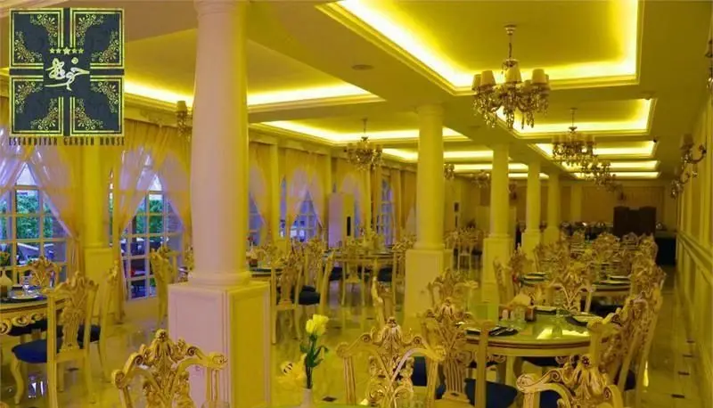 نمایی از سالن بزرگ و مجلل رستوران بین المللی خوارزمی با چیدمان شیک میز و صندلی‌های سلطنتی طلایی، لوسترهای زیبا و نورپردازی گرم.