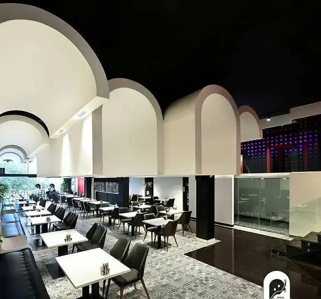 دکوراسیون داخلی مدرن و زیبای فست فود و کافی شاپ لمنز؛ با طاق‌های سفید، سقف مشکی و چیدمان لوکس میز و صندلی‌ها در فضایی دلنشین و دنج.