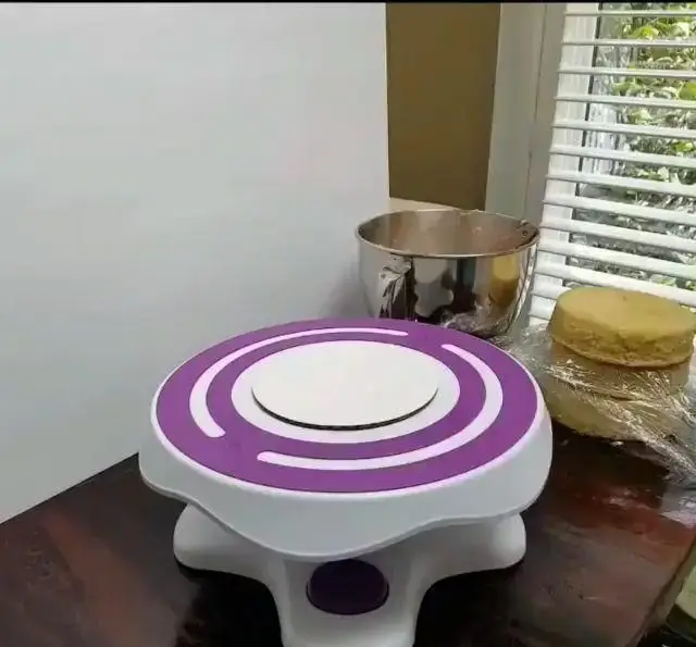 گردان کیک بنفش و سفید با تخته زیر کیک، آماده برای تزئین. لوازم قنادی و ابزار شیرینی پزی برای تهیه کیک دست ساز.