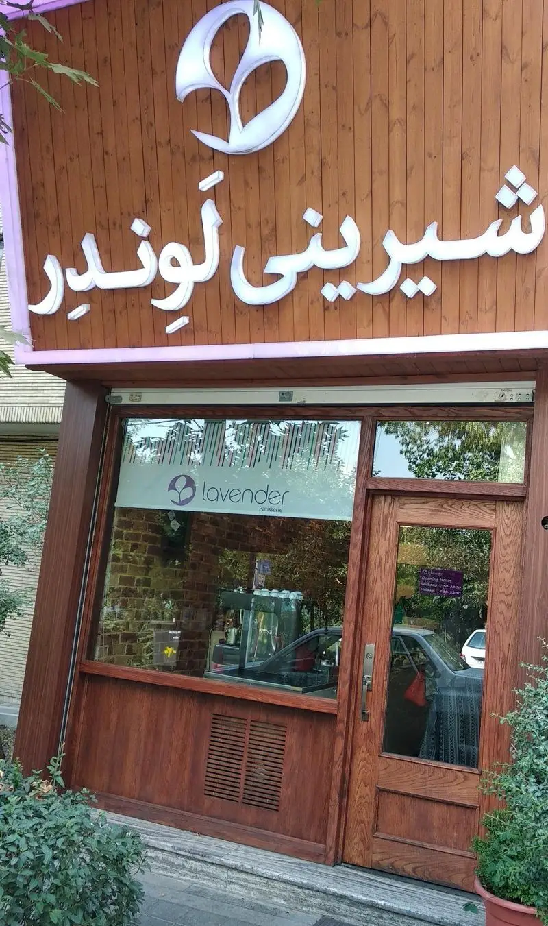 نمای بیرونی فروشگاه شیرینی لوندر با تابلوی روشن، طرح چوب و لوگوی زیبای گل اسطوخودوس. قنادی مدرن و دلنشین.