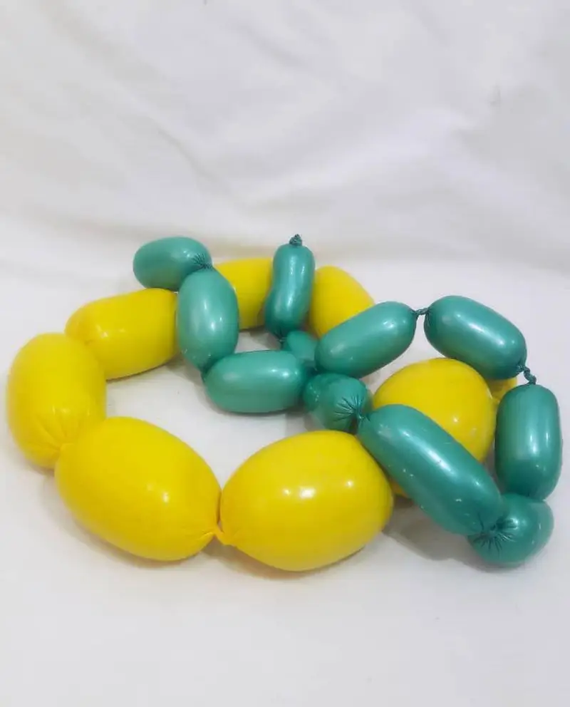 سوسیس‌های خانگی مامی فود در رنگ‌های زرد و سبزآبی، آماده برای طبخ و لذت بردن از غذایی سالم و خوشمزه.