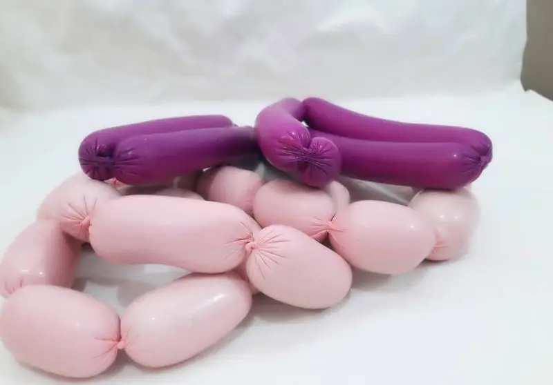 محصولات غذای خونگی مامی فود: سوسیس‌های بنفش و صورتی با کیفیت عالی، آماده برای طبخ. بهترین انتخاب برای یک وعده سالم.