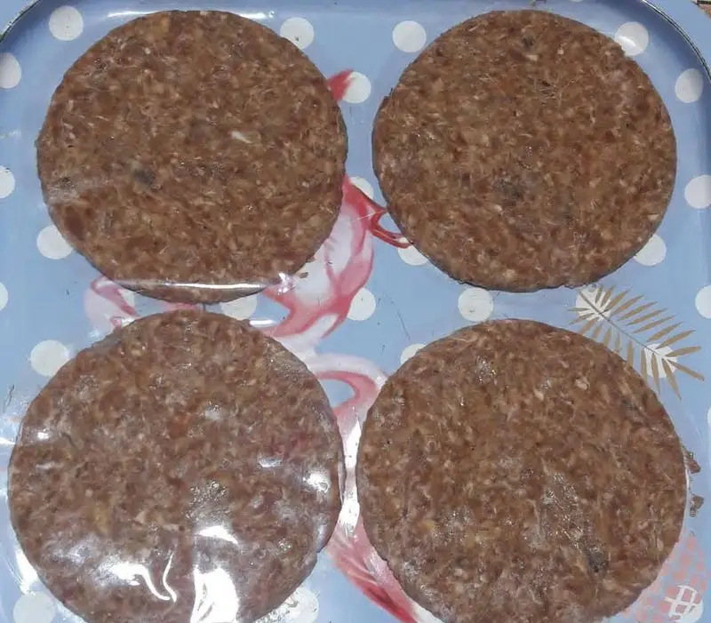 چهار همبرگر خانگی تازه مامی فود، با گوشت چرخ کرده با کیفیت، آماده طبخ روی سینی آبی طرح دار. طعمی اصیل و به یادماندنی.