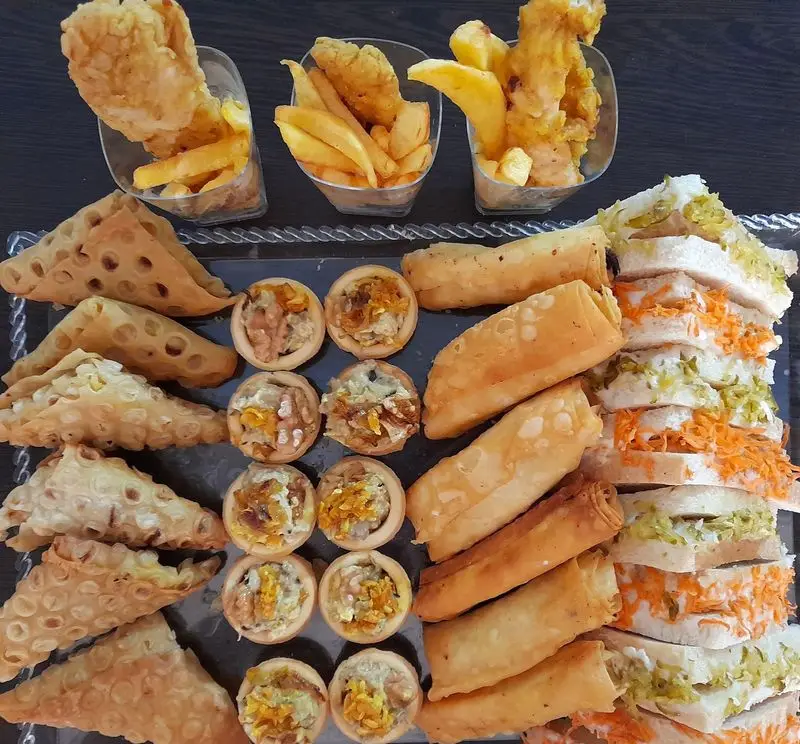 سینی متنوع غذای خونگی مامی فود شامل فینگرفودهای خوشمزه، تارت، ساندویچ، رول، مرغ سوخاری و سیب‌زمینی برای مهمانی‌ها و پذیرایی‌های خاص.