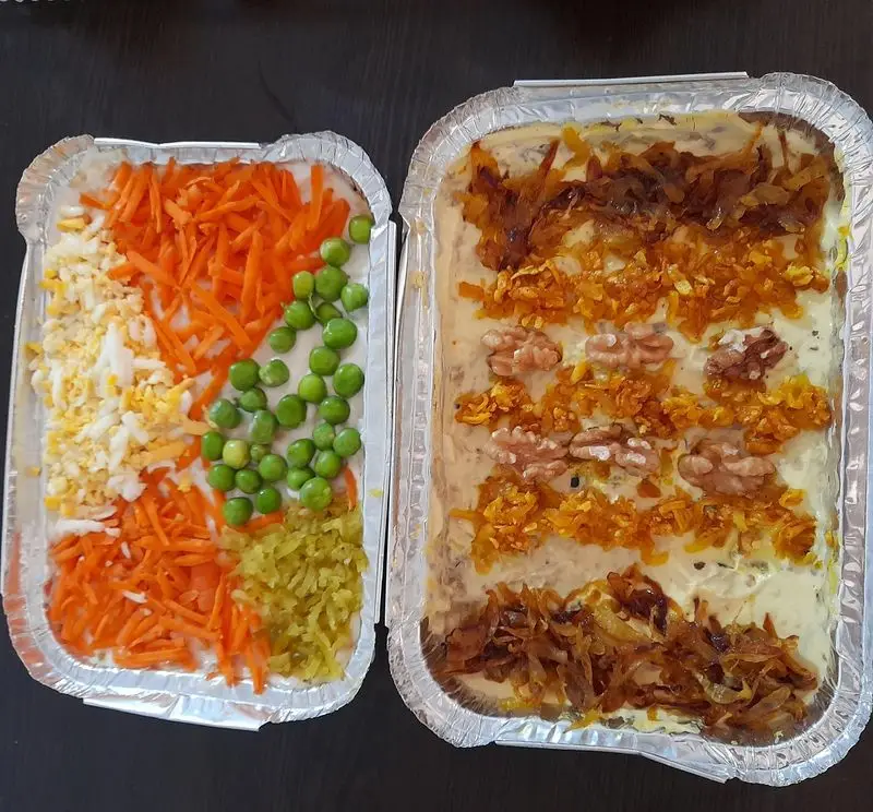 غذای خونگی مامی فود: دو سینی سالاد الویه خانگی با تزیین هویج، نخودفرنگی، تخم‌مرغ، پیازداغ و گردو. مناسب مهمانی‌ها.