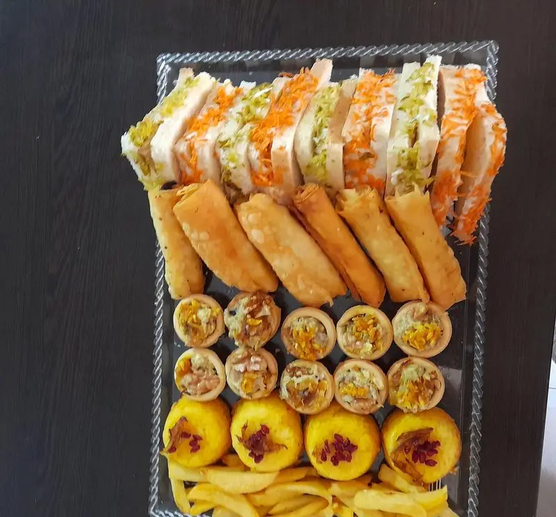 سینی فینگرفود و غذای خونگی مامی فود: ساندویچ، رول، تارت‌های متنوع، پیش غذای لقمه‌ای و سیب‌زمینی برای مهمانی.