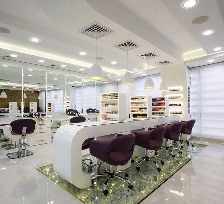 طراحی دکوراسیون داخلی مدرن و لوکس سالن زیبایی و آرایشگاه زنانه با صندلیهای چرمی بنفش، میزهای سفید و نورپردازی شیک سقف