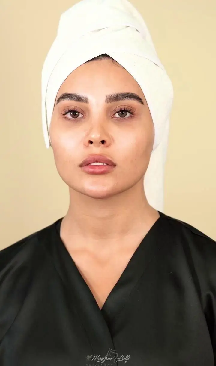 پرتره زنی با حوله سفید روی سر و لباس مشکی پس از انجام خدمات مراقبت از پوست و فیشیال صورت در کلینیک زیبایی مرجان لطفی با پوست درخشان و طبیعی