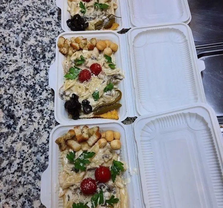 چهار ظرف غذای بیرون بر پاستا با سس خامه، گوجه گیلاسی و زیتون، کروتون و جعفری، آماده ارسال از رستوران پروفسور.