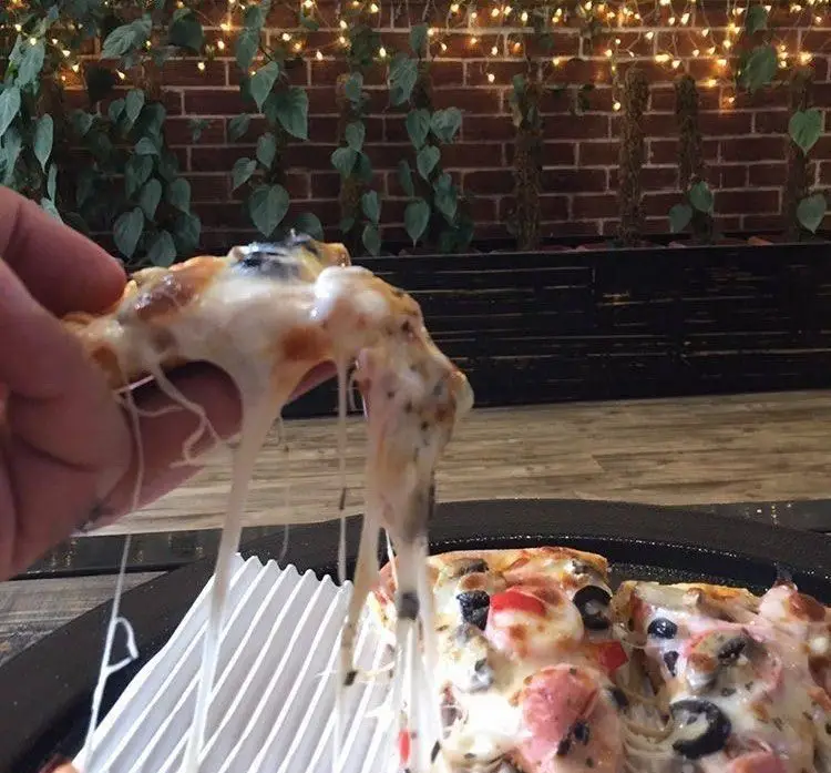 لذت کشسانی پنیر پیتزای داغ با قارچ و زیتون در محیط دلنشین رستوران پروفسور، بهترین انتخاب برای غذای خوشمزه.