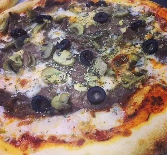 پیتزای بی‌نظیر رستوران پروفسور: ترکیبی وسوسه‌انگیز از قارچ تازه، زیتون سیاه، تکه‌های گوشت، پنیر طلایی و سبزیجات معطر آماده سرو.