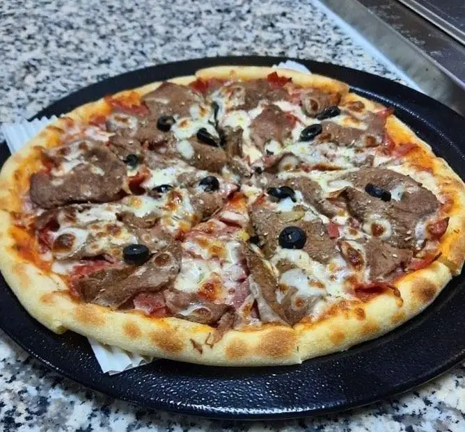 پیتزا مخصوص گوشت و پنیر رستوران پروفسور، با زیتون سیاه و سس گوجه‌فرنگی. تجربه‌ای لذیذ از فست فودهای باکیفیت و خوشمزه.